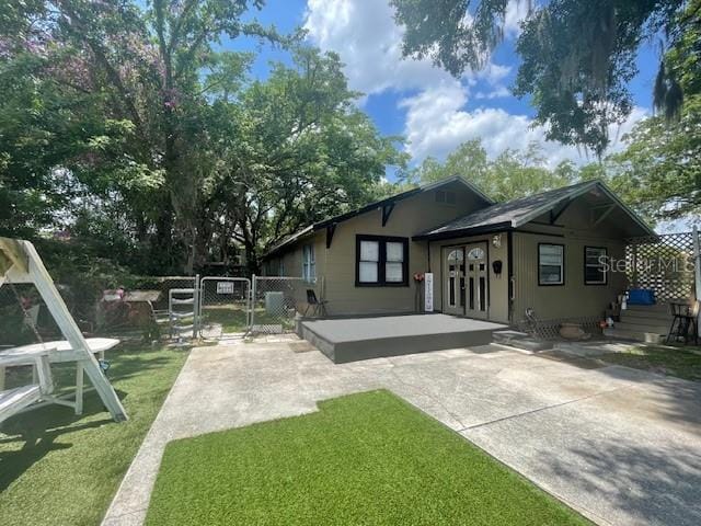 rear view of property featuring a yard and a patio area