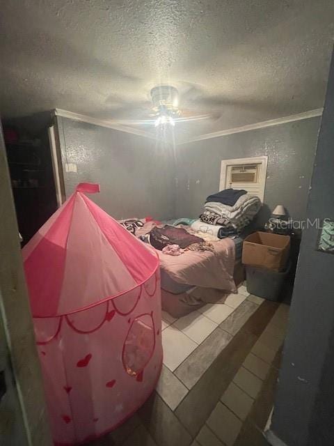 bedroom with ceiling fan, crown molding, a textured ceiling, and tile patterned flooring