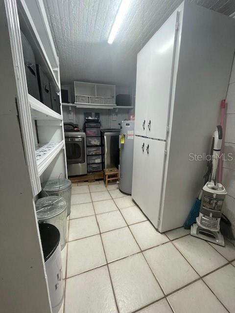 kitchen with water heater, light tile patterned floors, and washer / dryer