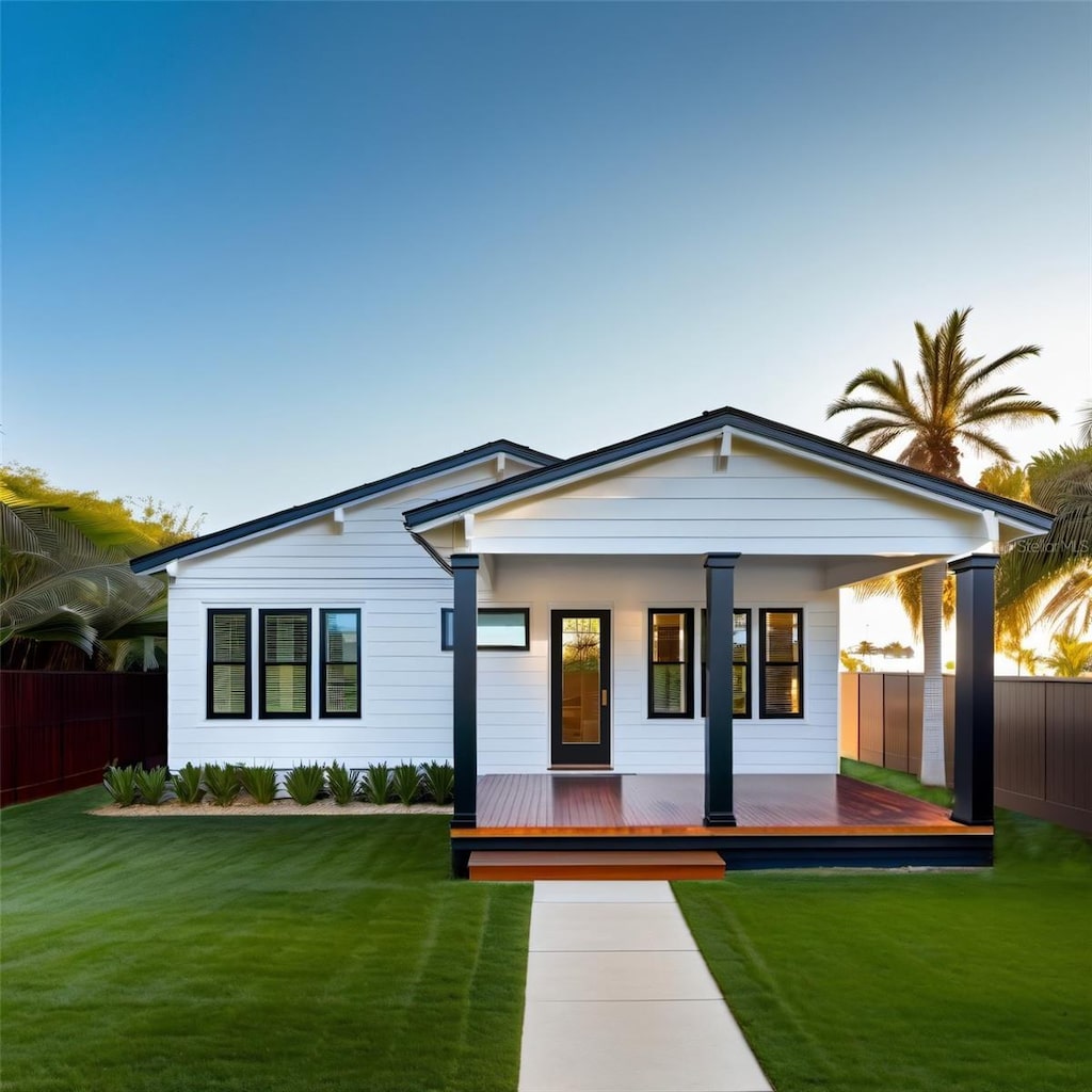 view of front of home featuring a wooden deck, a yard, and a porch