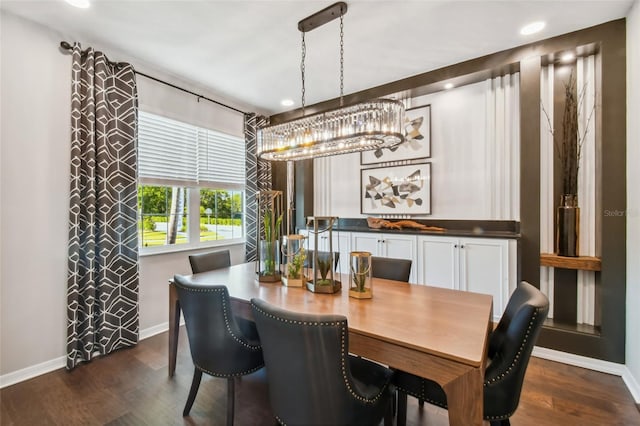 dining room with dark hardwood / wood-style flooring and an inviting chandelier