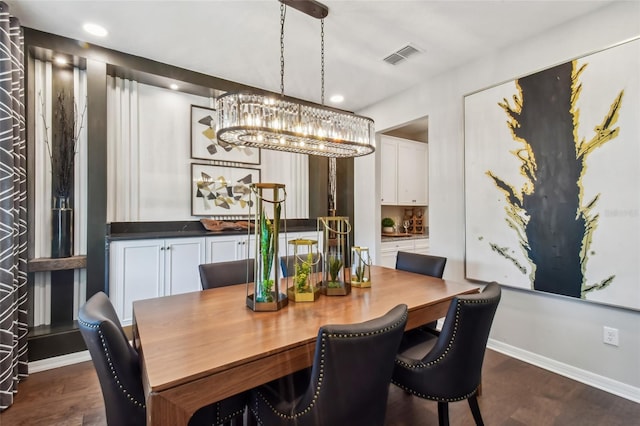 dining room with dark wood-type flooring and a chandelier