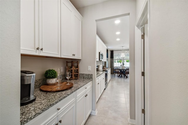 kitchen featuring white cabinetry, light stone counters, and appliances with stainless steel finishes