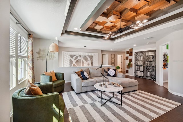 living room featuring hardwood / wood-style floors, a chandelier, ornamental molding, and a tray ceiling