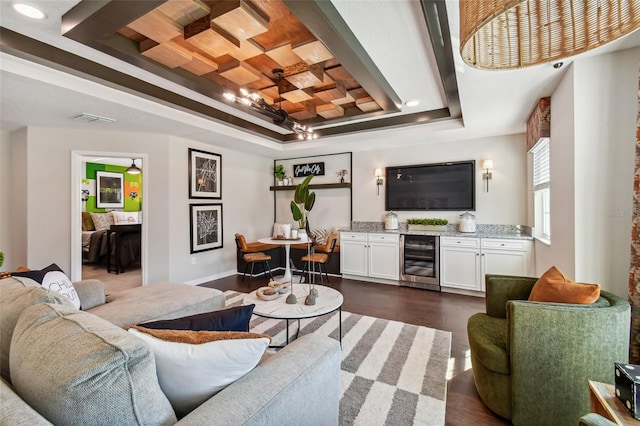 living room featuring indoor bar, dark hardwood / wood-style floors, a raised ceiling, and beverage cooler