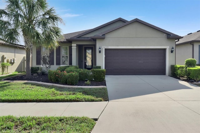 single story home with concrete driveway, an attached garage, and stucco siding