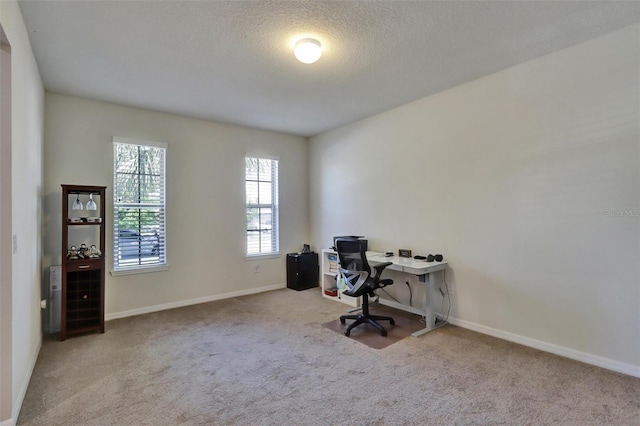 carpeted office space featuring a textured ceiling