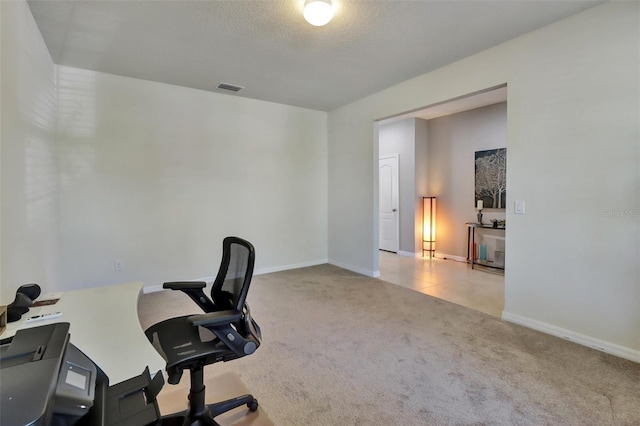 carpeted office space with a textured ceiling