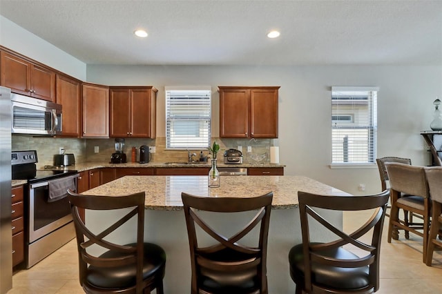 kitchen featuring decorative backsplash, stainless steel appliances, and a healthy amount of sunlight