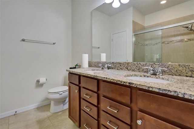 bathroom with tile patterned floors, vanity, a shower with shower door, and toilet