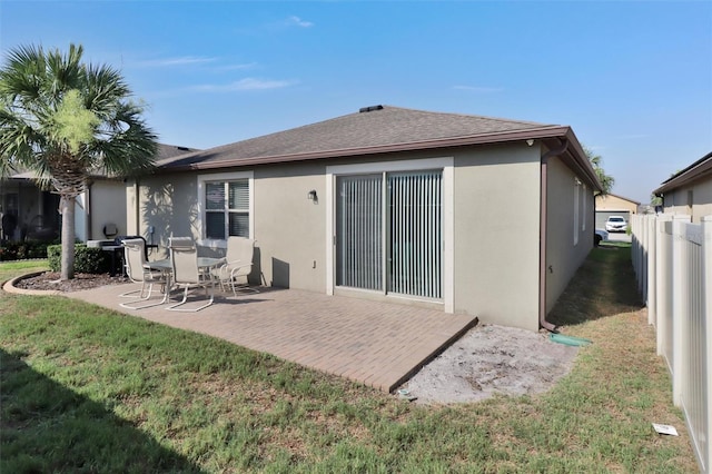 rear view of property featuring a patio area and a lawn