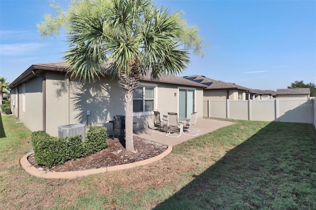 back of property featuring a patio, central AC unit, and a lawn