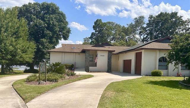 view of front of home with driveway, a front lawn, and stucco siding