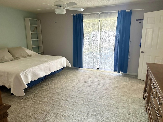 carpeted bedroom with a textured ceiling and a ceiling fan