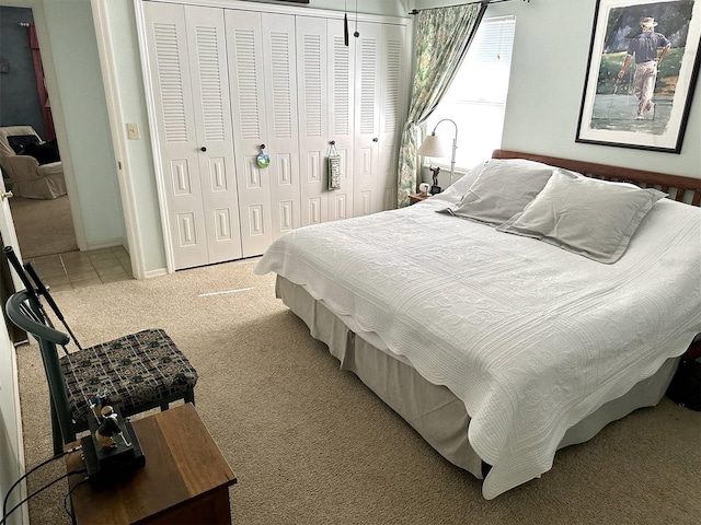 bedroom featuring a closet, light carpet, and light tile patterned floors