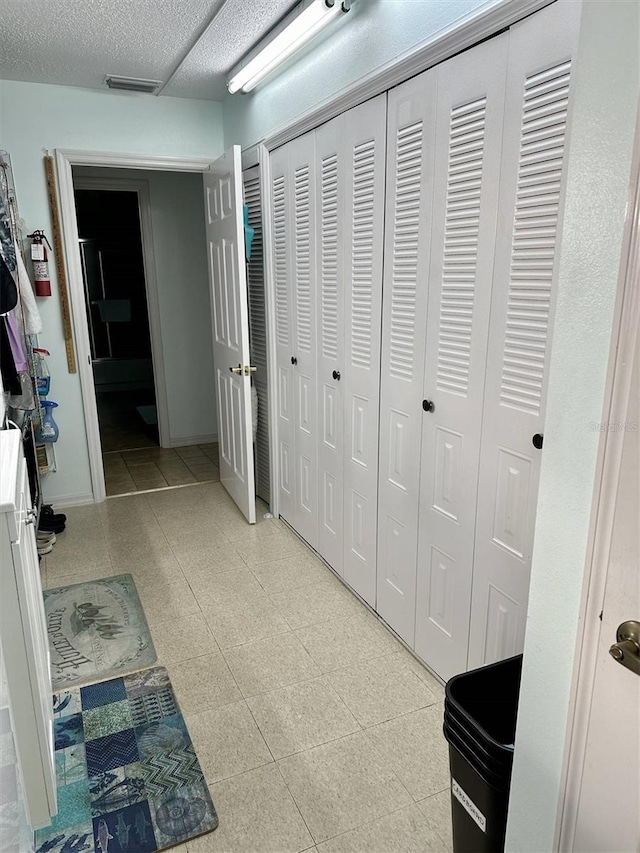 hall with a textured ceiling and visible vents