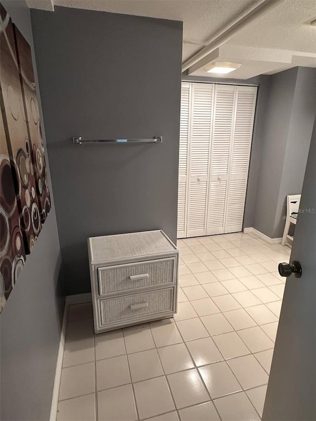 bathroom featuring a textured ceiling, baseboards, and tile patterned floors