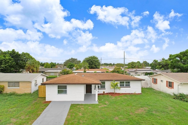 single story home featuring a front lawn and a patio area