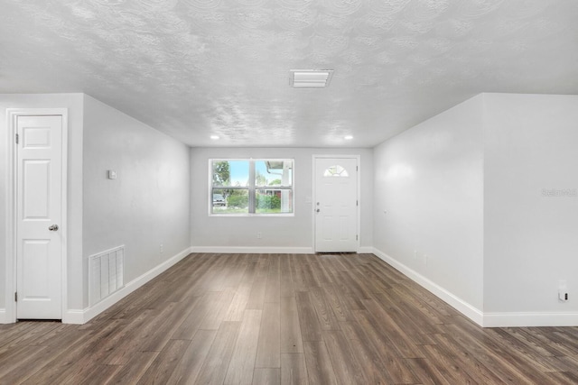 entryway with a textured ceiling and dark hardwood / wood-style floors