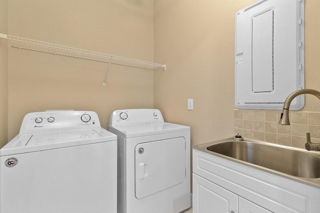 laundry area featuring washing machine and dryer, cabinets, and sink