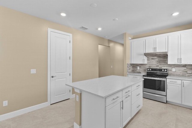 kitchen with a center island, white cabinets, stainless steel electric range oven, light tile patterned floors, and backsplash