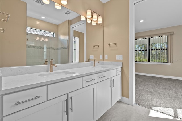 bathroom with vanity, tile patterned flooring, and tiled shower