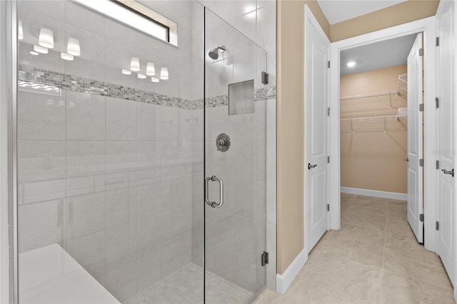 bathroom featuring a shower with shower door and tile patterned floors