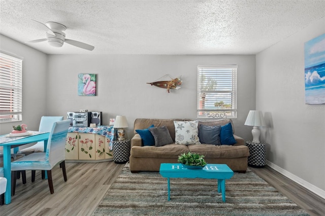 living room featuring a wealth of natural light, hardwood / wood-style flooring, ceiling fan, and a textured ceiling