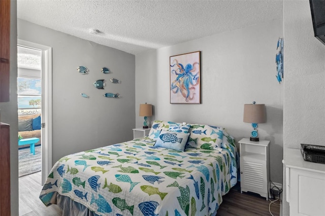 bedroom featuring dark hardwood / wood-style flooring and a textured ceiling