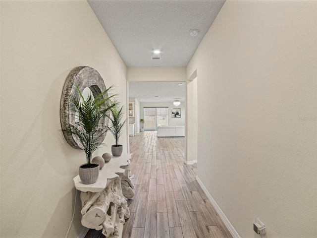 corridor with hardwood / wood-style floors