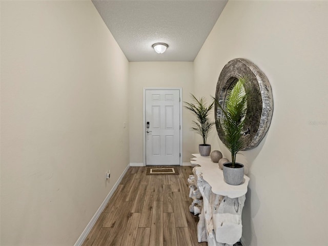 doorway to outside featuring a textured ceiling and hardwood / wood-style flooring