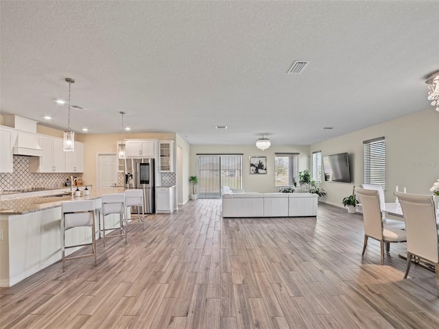 living room with a textured ceiling and light wood-type flooring