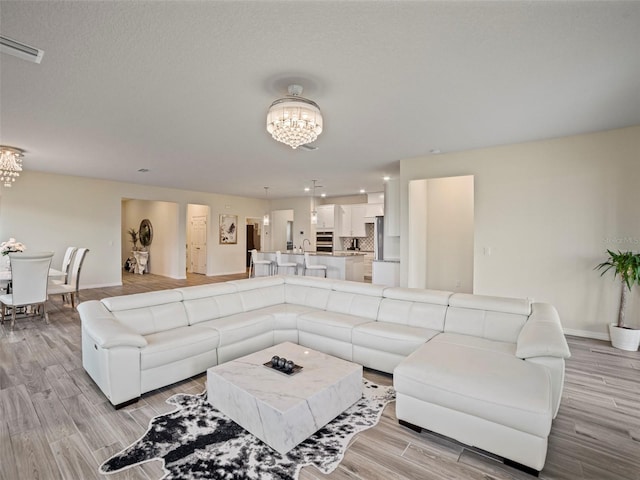 living room featuring a notable chandelier and light hardwood / wood-style flooring