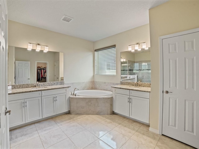 bathroom with vanity, tile patterned flooring, a textured ceiling, and separate shower and tub