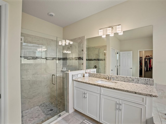 bathroom with tile patterned floors, an enclosed shower, and vanity