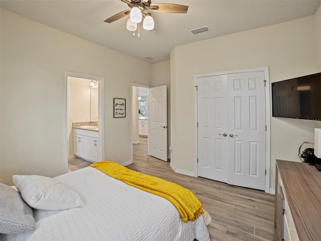 bedroom featuring ceiling fan, light hardwood / wood-style floors, connected bathroom, and a closet