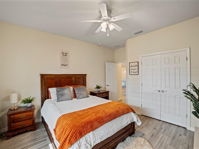 bedroom featuring light wood-type flooring, ceiling fan, and a closet