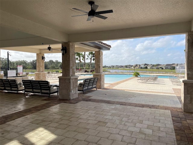 view of patio / terrace with ceiling fan and a community pool