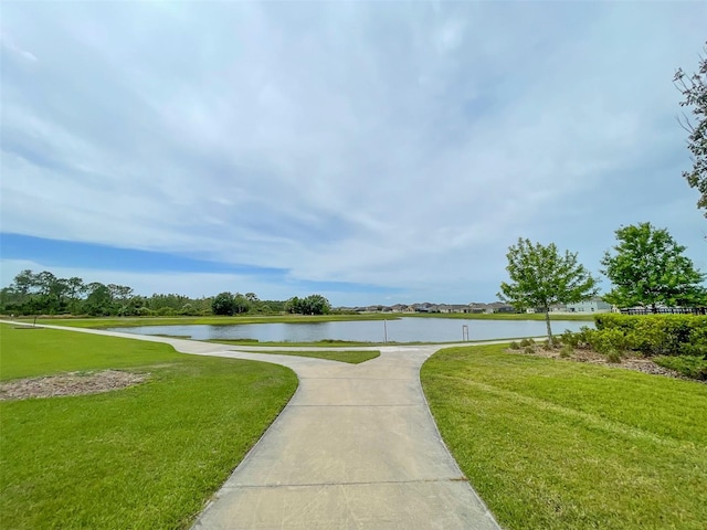 view of property's community featuring a lawn and a water view