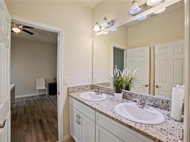 full bathroom with double vanity, a sink, a ceiling fan, and wood finished floors
