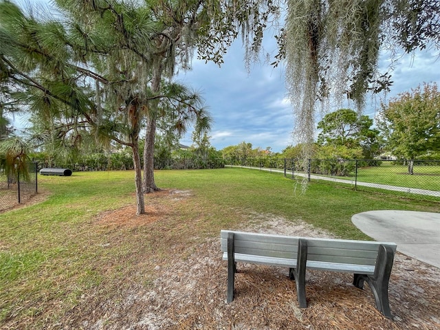 view of home's community with a lawn and fence