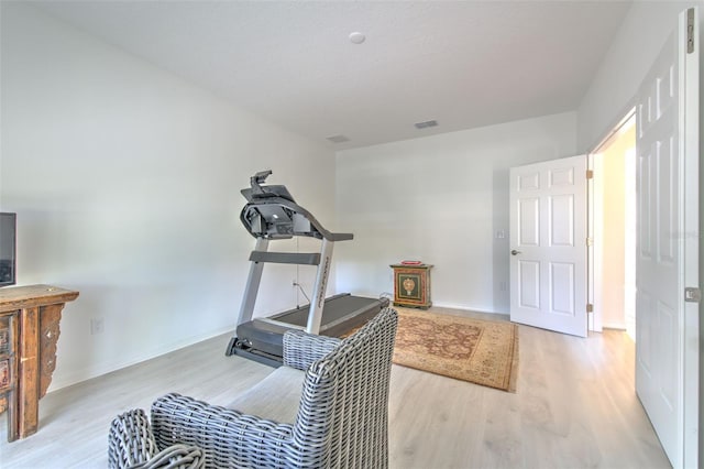 workout area with light hardwood / wood-style flooring