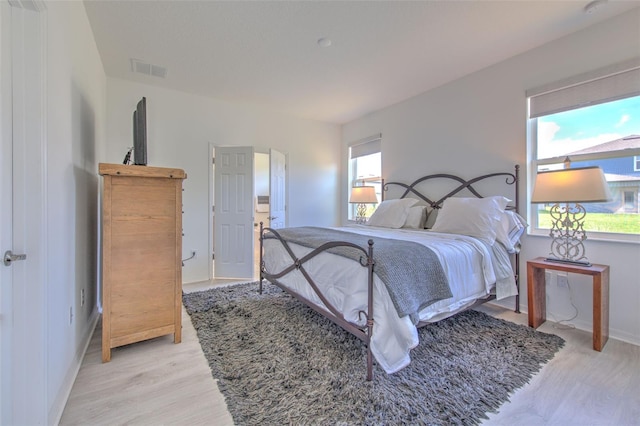 bedroom with light hardwood / wood-style flooring and multiple windows