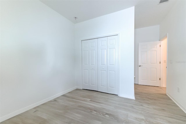 unfurnished bedroom featuring light hardwood / wood-style flooring and a closet