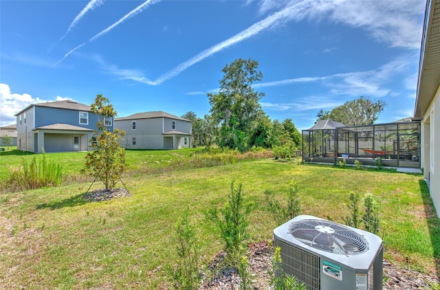 view of yard with a lanai and central AC