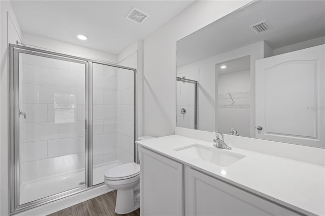 bathroom with vanity, toilet, walk in shower, and wood-type flooring