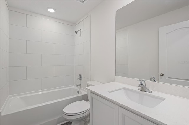 full bathroom featuring vanity, tiled shower / bath combo, and toilet