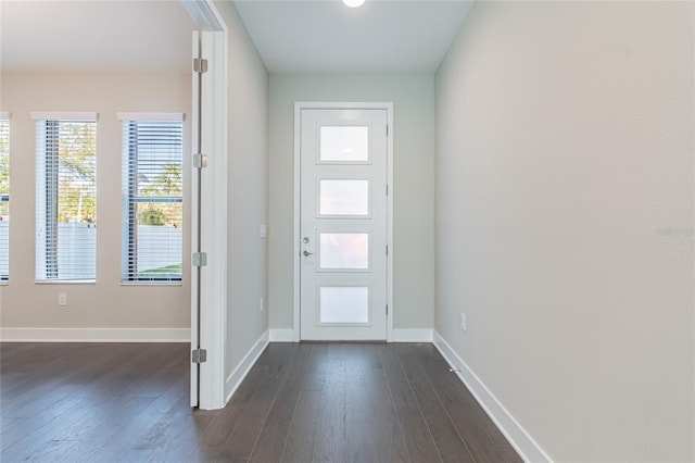 foyer entrance featuring dark wood finished floors and baseboards