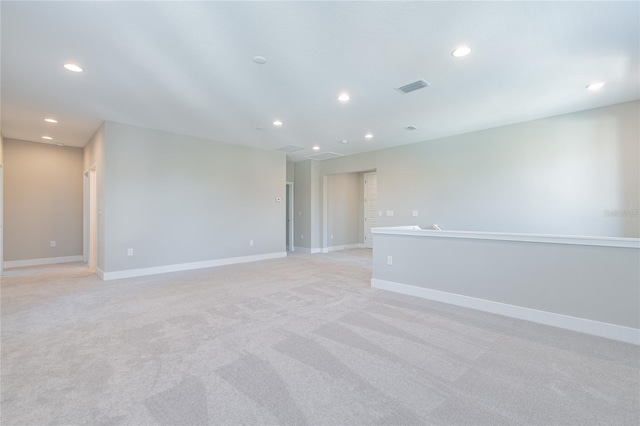 unfurnished room featuring light colored carpet, recessed lighting, visible vents, and baseboards