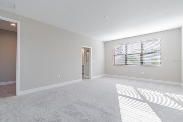 unfurnished room featuring light colored carpet, visible vents, and baseboards